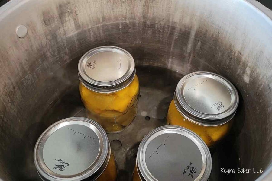 pressure canner with water and cans of pumpkin