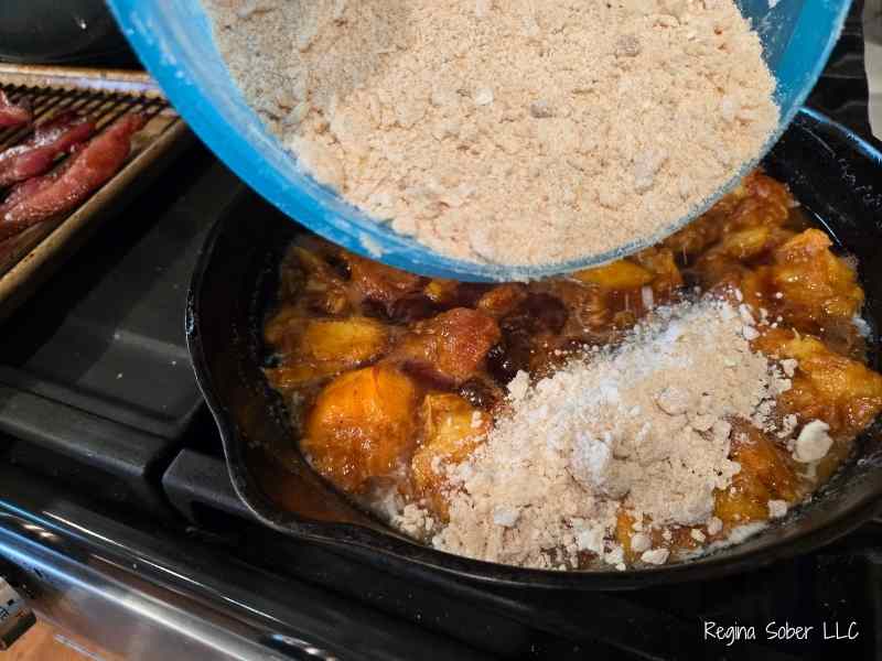 spreading cobbler ontop of softened peaches