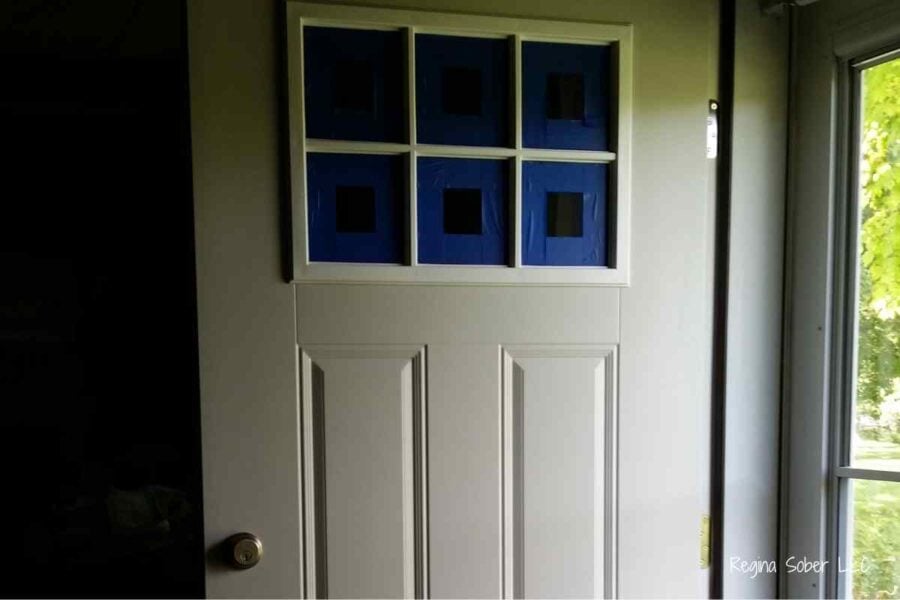 taped windows of door before painting