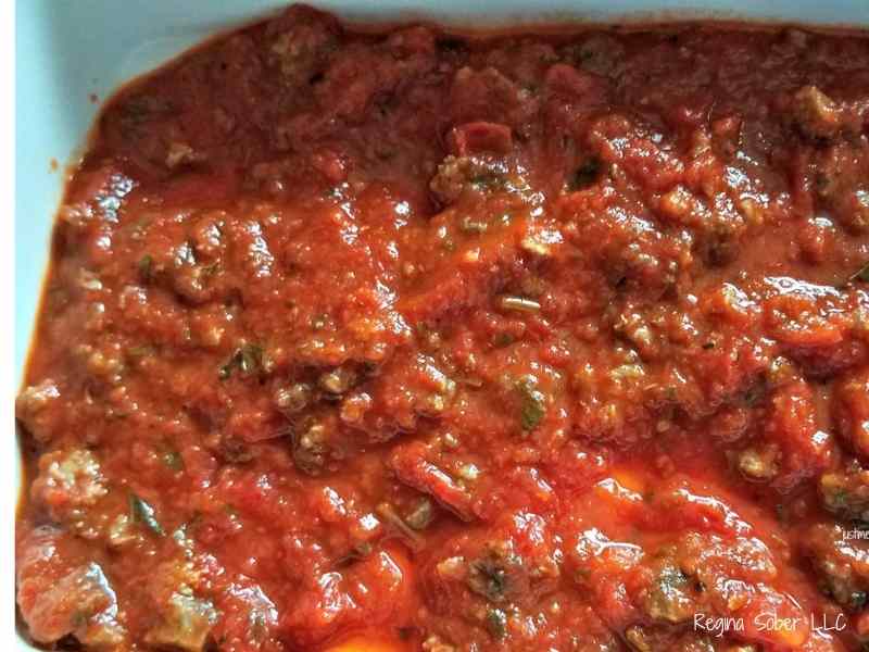 lasagna sauce poured at the bottom of a baking dish keeps the noodles from sticking