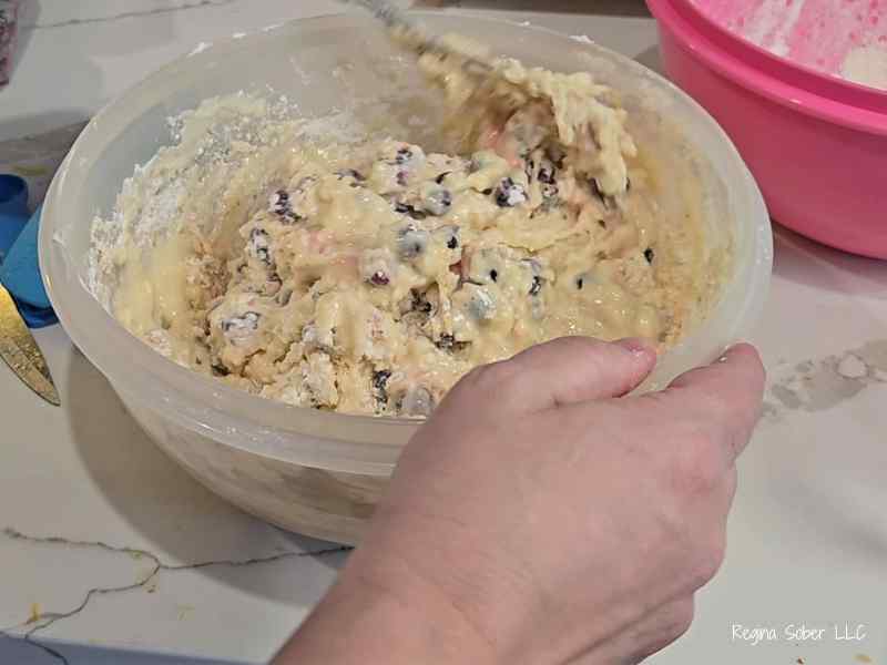 mixing batter with blueberries