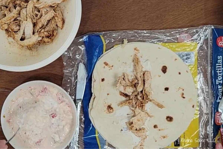 filling tortillas with shredded chicken