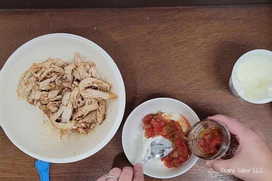 bowl if shredded chicken with salsa and sour cream