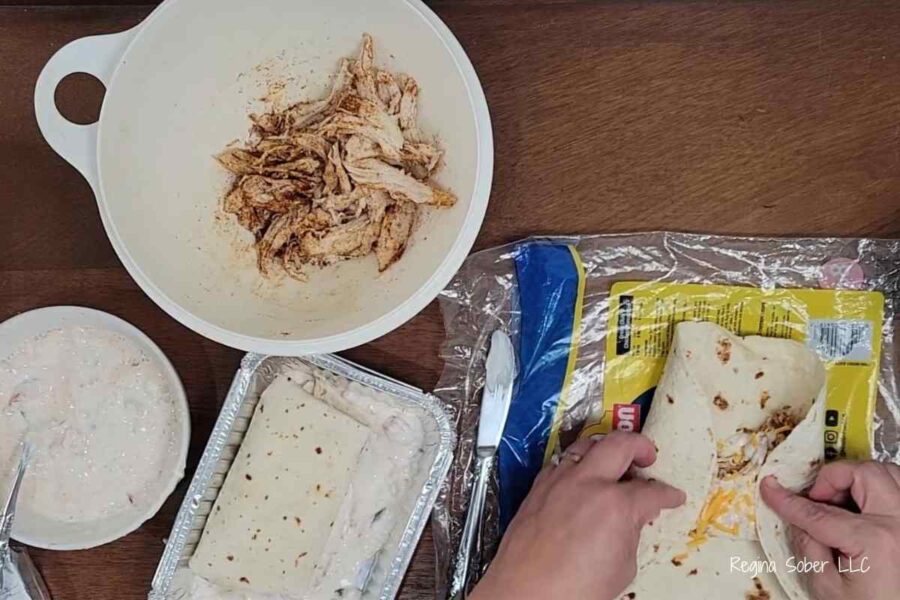 folding tortillas into enchiladas