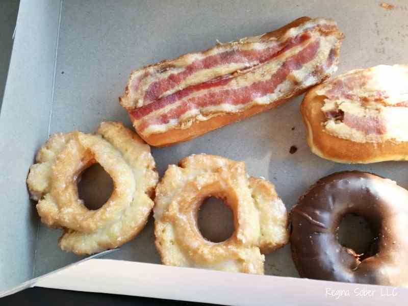 box of donuts including a squealer covered in bacon.