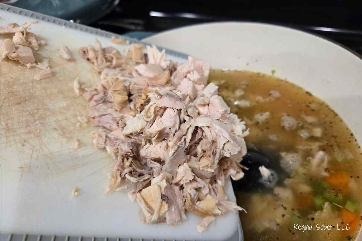 adding chopped chicken to soup