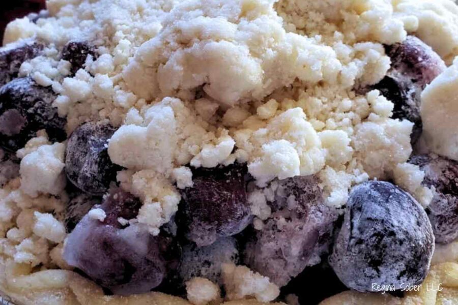 cherries with crumb topping on top in a pie crust