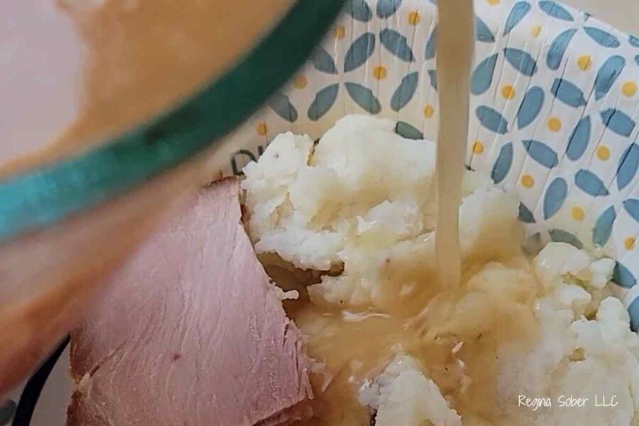 pouring gravy onto mashed potatoes