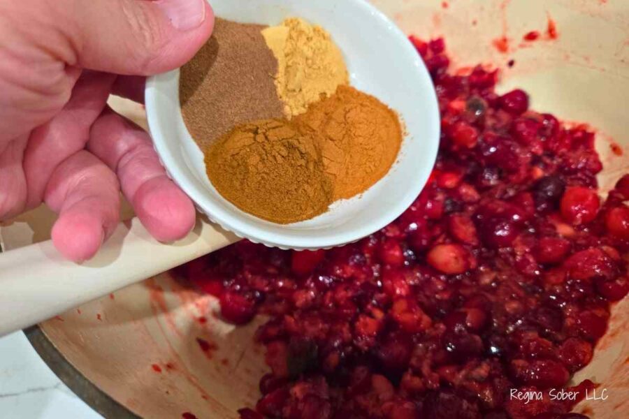 adding allspice, ground cinnamon, ground ginger and ground cloves in christmas jam