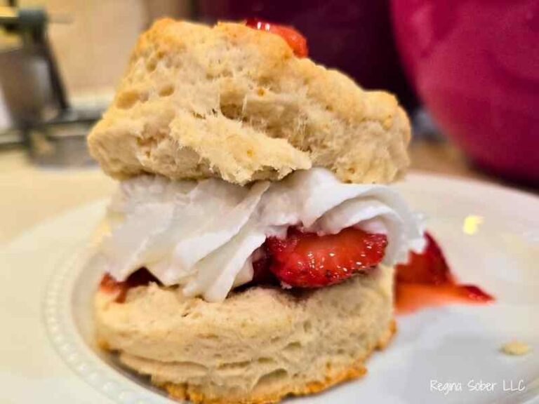 A tall stack of biscuits, berries, and whipped cream ready to serve.