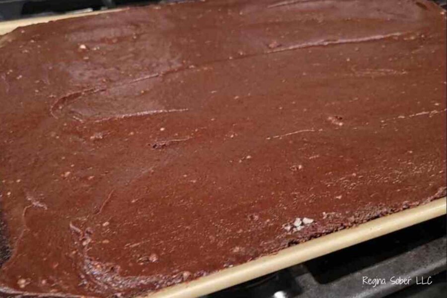 frosted cooled cake with chocolate frosting in sheet pan