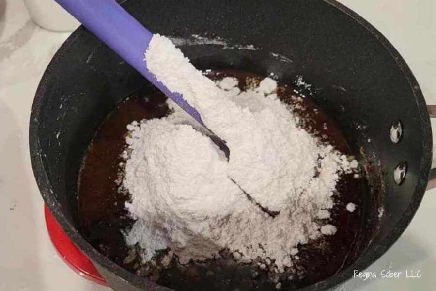 powdered sugar and cocoa powder in pan making chocolate frosting