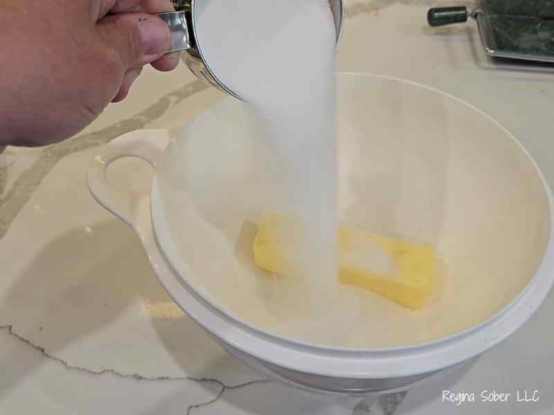 measure white sugar and softened butter into a bowl