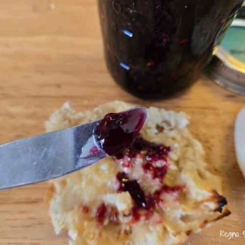putting blackberry jam on toasted English muffins for breakfast or snacks