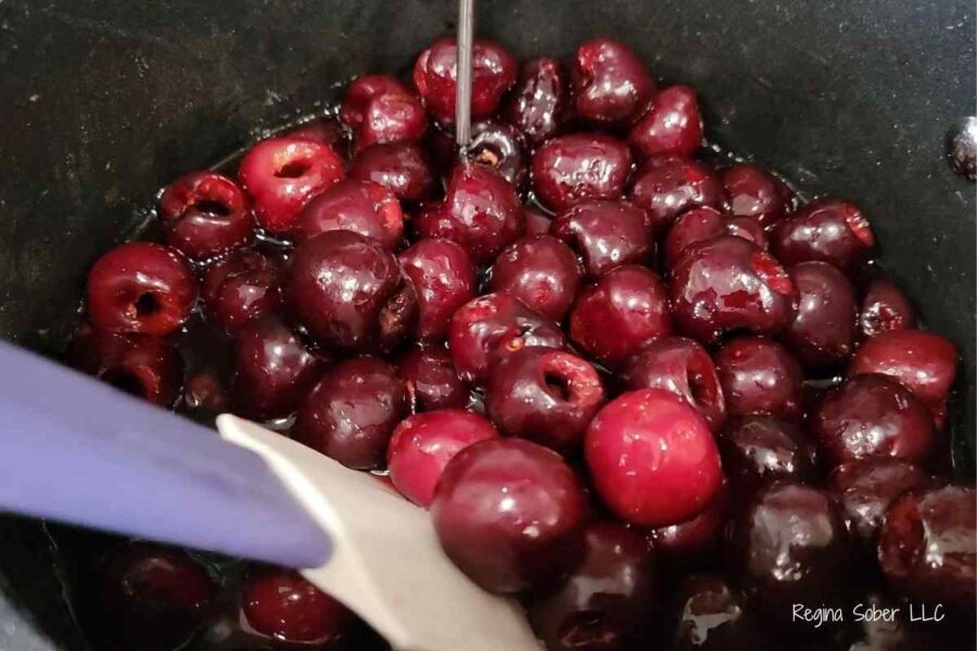 stirring whole bing cherries in completely melted sugar water mix