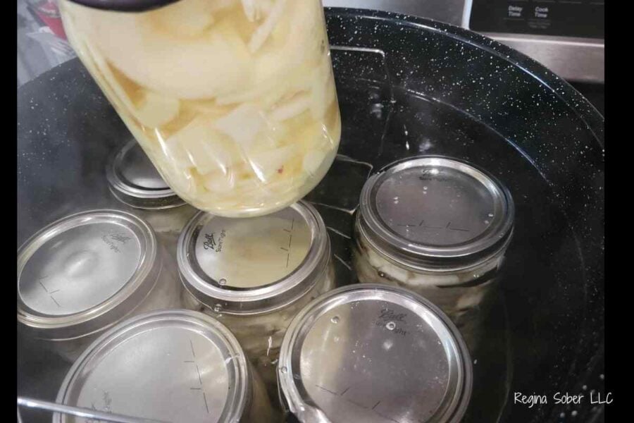 boiling water canner with quart jars of apple slices