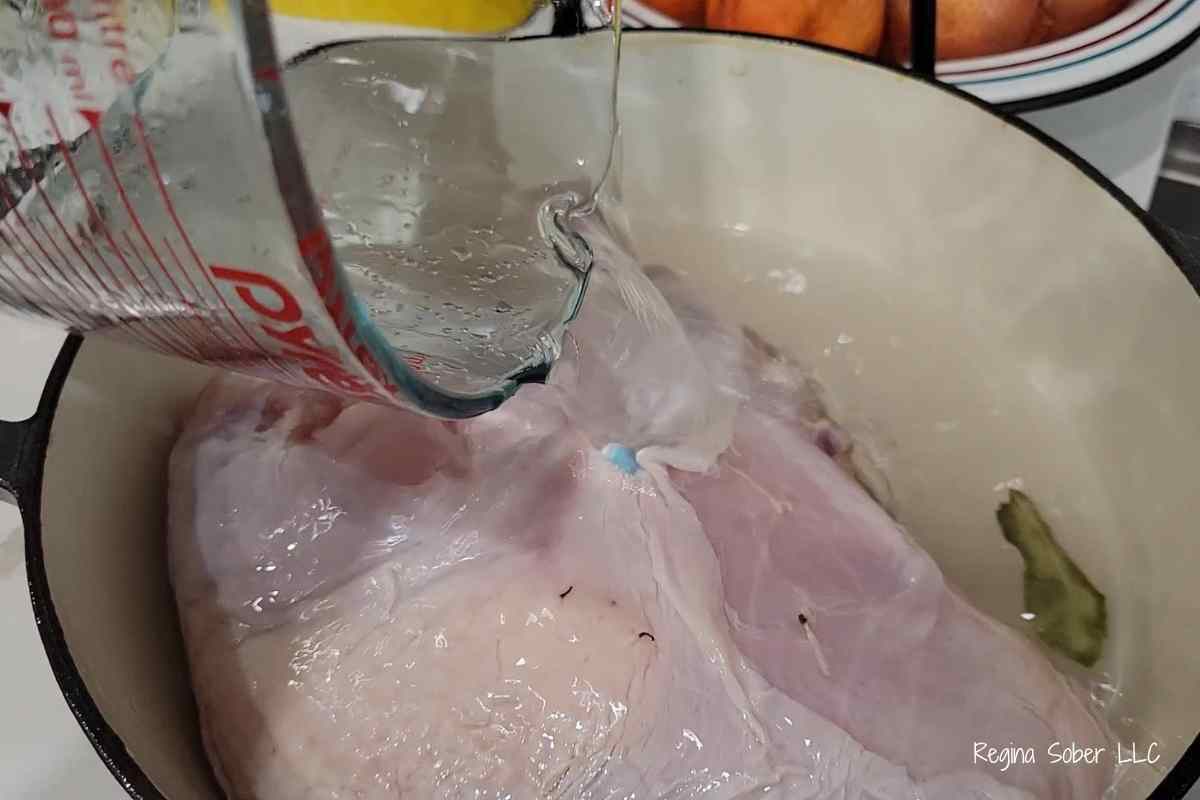 pouring wet brine on turkey in a large pot