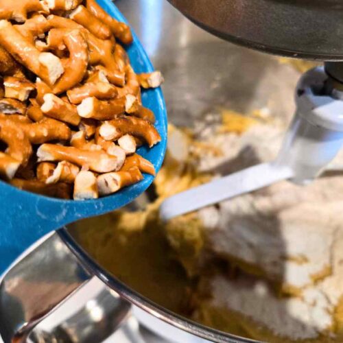 adding crushed crunchy pretzels into dough