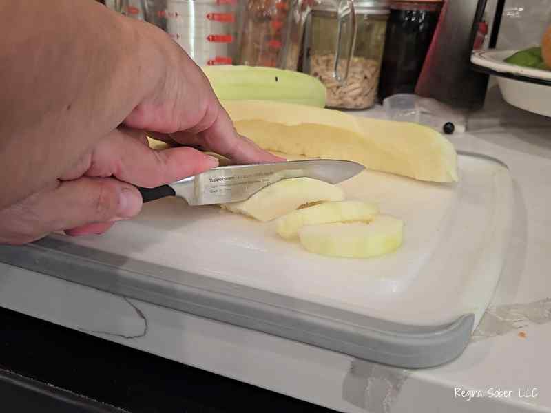 slice zucchini with knife and cutting board
