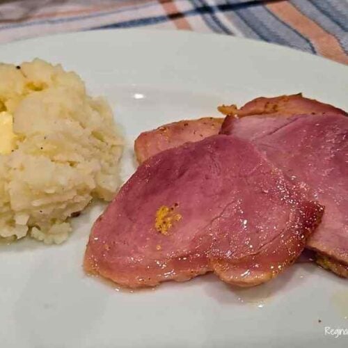 plated sliced ham with mashed potatoes