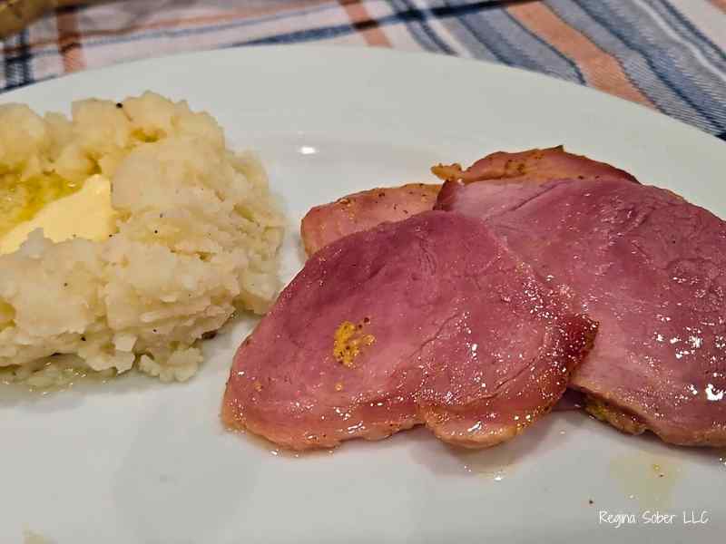 plated sliced ham with mashed potatoes