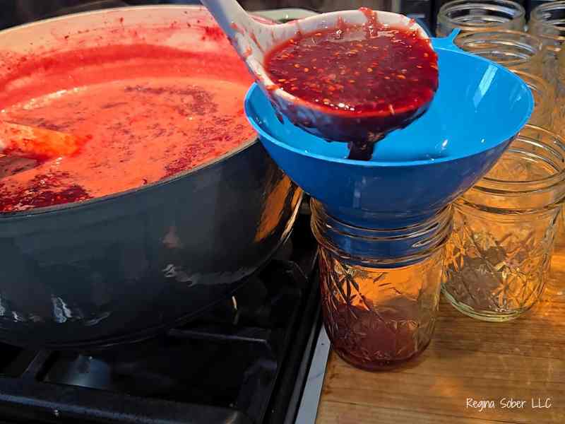pouring jam into half pint canning jars