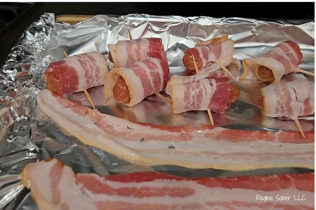 baking sheet covered in foil with wrapped sausages