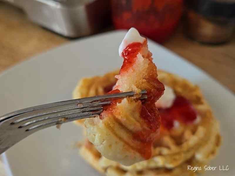 waffles with just enough sauce on them topped with whipped cream